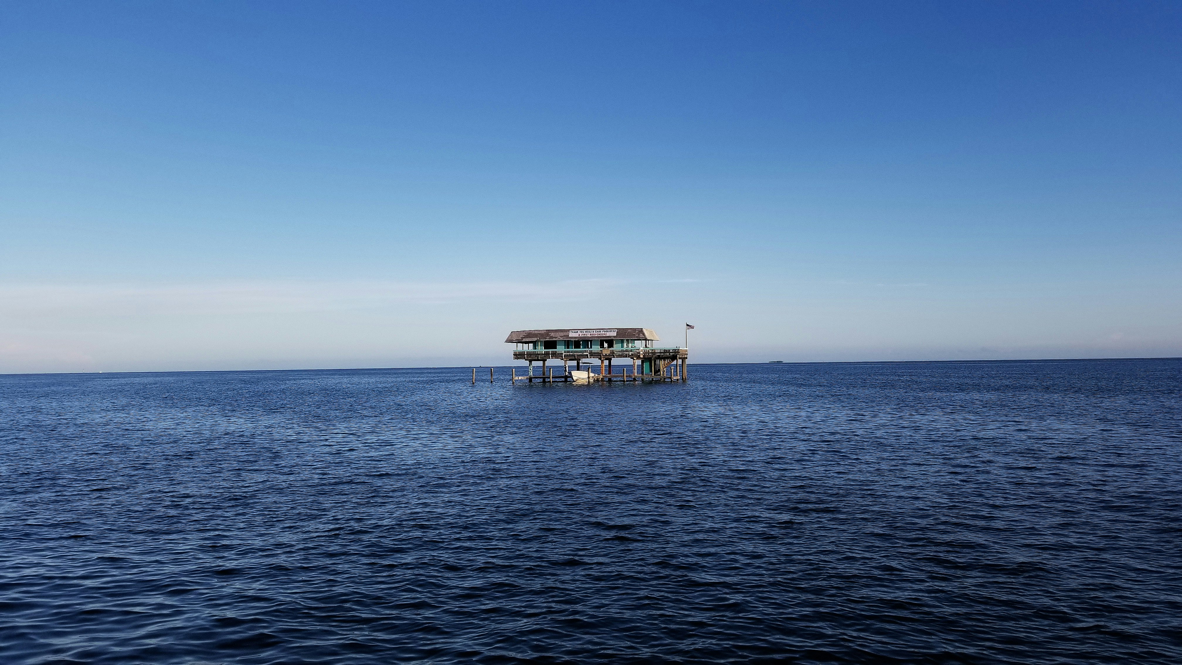 brown wooden house on sea during daytime